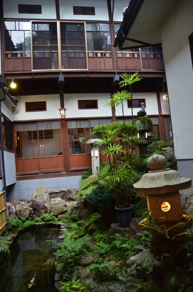 木造の客室に囲まれた中庭。池に錦鯉が泳ぎ、灯籠が灯る　／　05_nakaniwa_nishikigoi.jpg