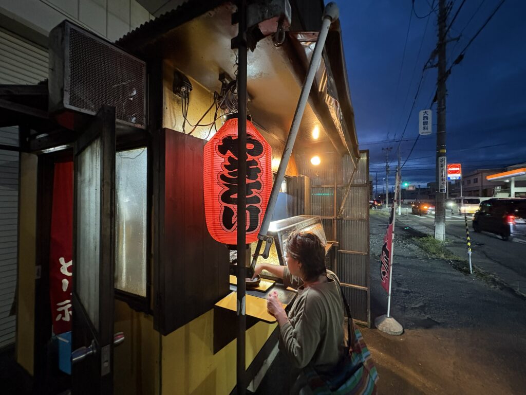 夜の駐車場の角に、赤提灯を灯したやきとりの小屋　／　08_torifuku_yakitori.jpg